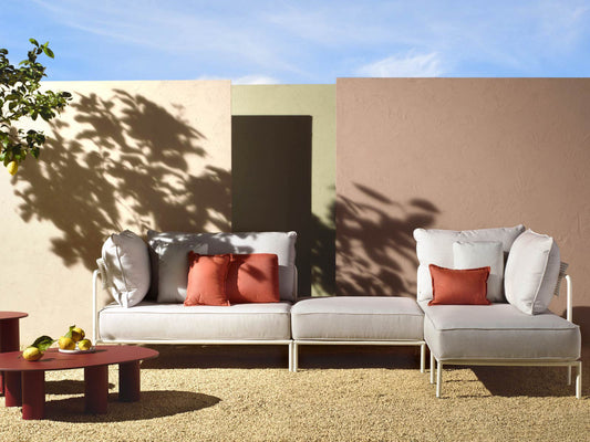 Flap 2902 modular outdoor sofa with cream cushions and terracotta accent pillows arranged on a contemporary patio.