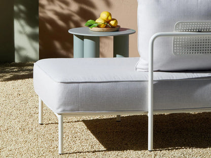 Close-up of the Flap 2902 outdoor daybed featuring a cream upholstered cushion, white metal frame, and integrated armrest.