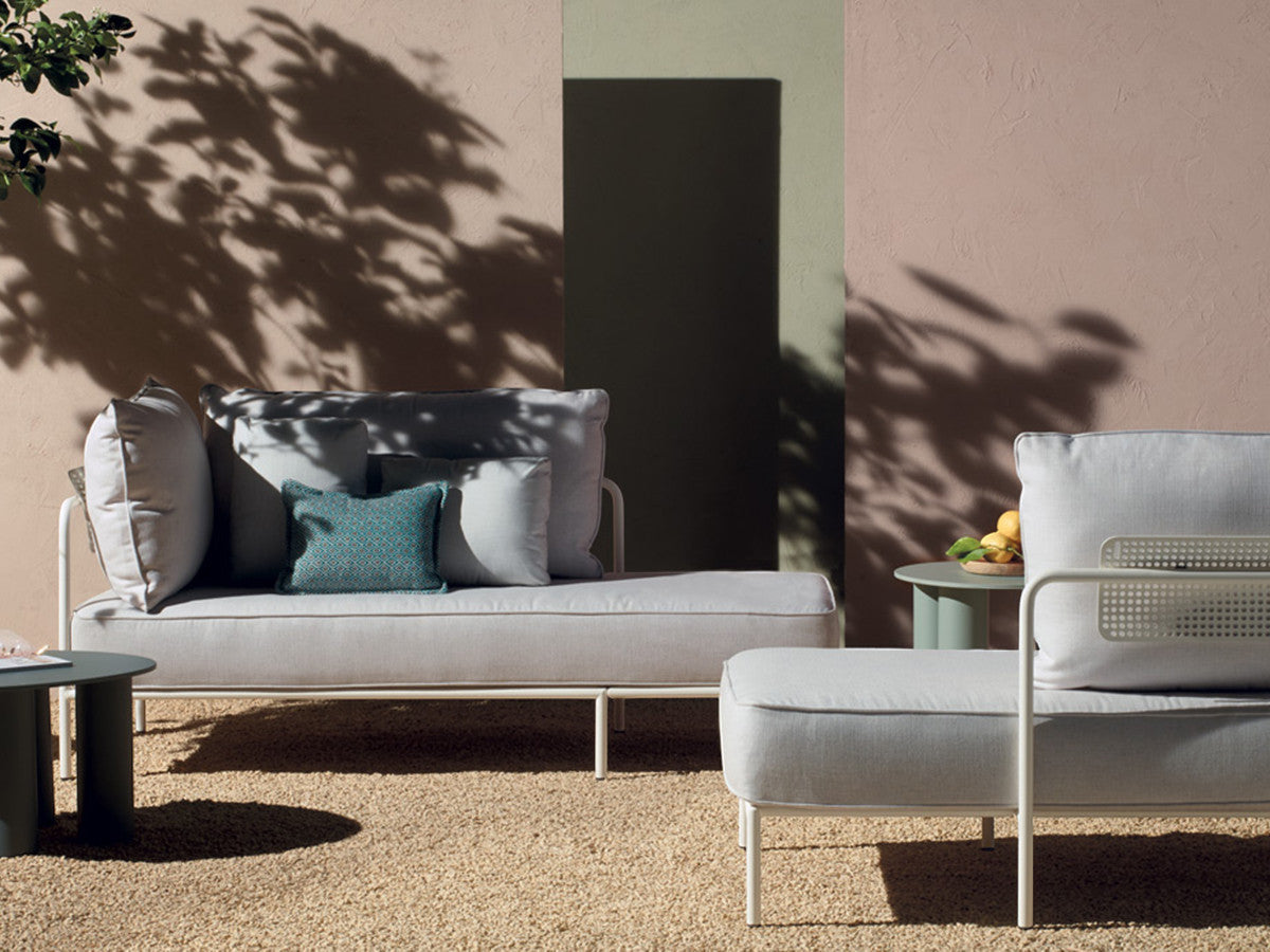 Flap 2902 modular outdoor sofa and daybed with cream cushions displayed on a contemporary patio with side tables.