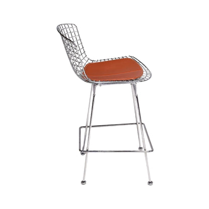 Profile view of a Harry Bertoia style wire bar stool featuring a polished chrome steel wire frame, integrated footrest and premium tan leather seat pad, ideal for modern kitchen islands, breakfast bars and luxury commercial interiors.