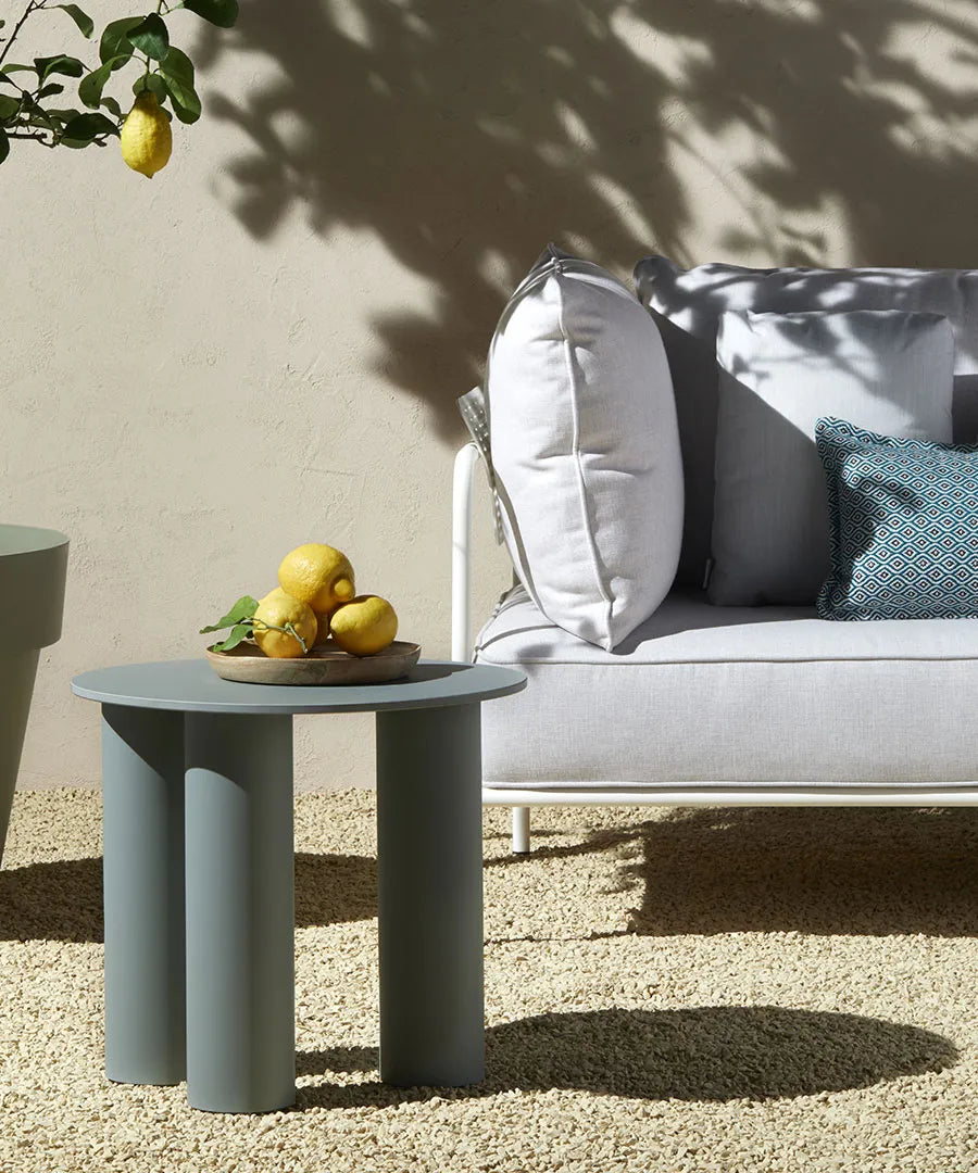 S•CAB Hyppo Ø50 cm outdoor coffee table beside the Brezza outdoor sofa in a contemporary garden lounge setting.