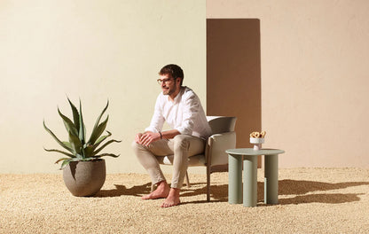 S•CAB Hyppo Ø50 cm outdoor coffee table beside a lounge chair in a contemporary outdoor relaxation area.