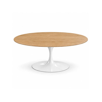 Italian oval natural oak wood dining table with a glossy white tulip pedestal base on a white background.