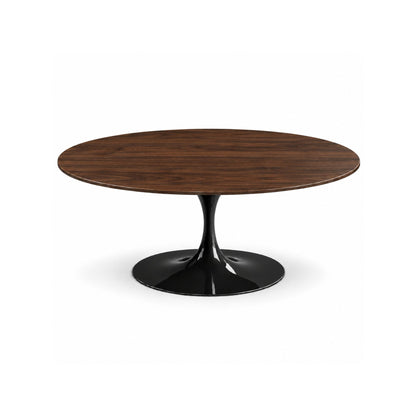 Italian oval walnut wood dining table with a glossy black tulip pedestal base on a white background.