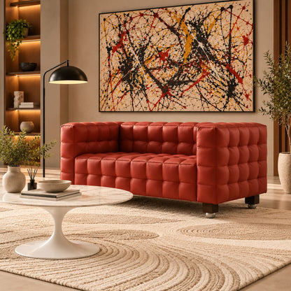 Josef Hoffmann Kubus red leather sofa with signature cube-tufted upholstery, paired with a white Saarinen Tulip marble coffee table in a contemporary luxury living room, showcasing iconic Bauhaus and mid-century modern designer furniture.