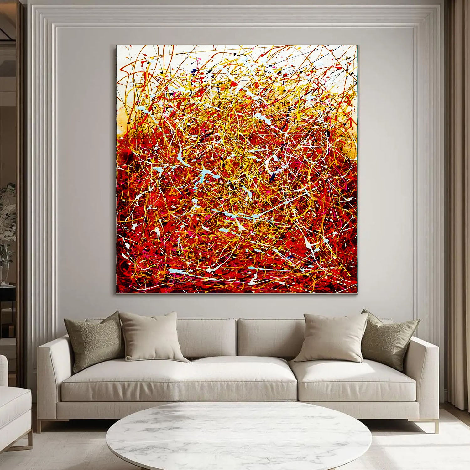 Abstract painting in a living room with a beige sofa and round coffee table.