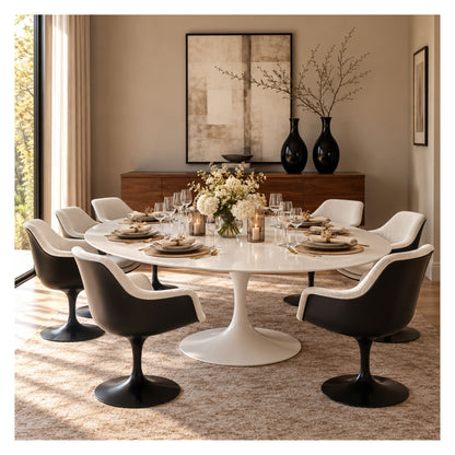 Large oval Tulip dining table with a glossy white top and pedestal base, surrounded by black and cream upholstered chairs