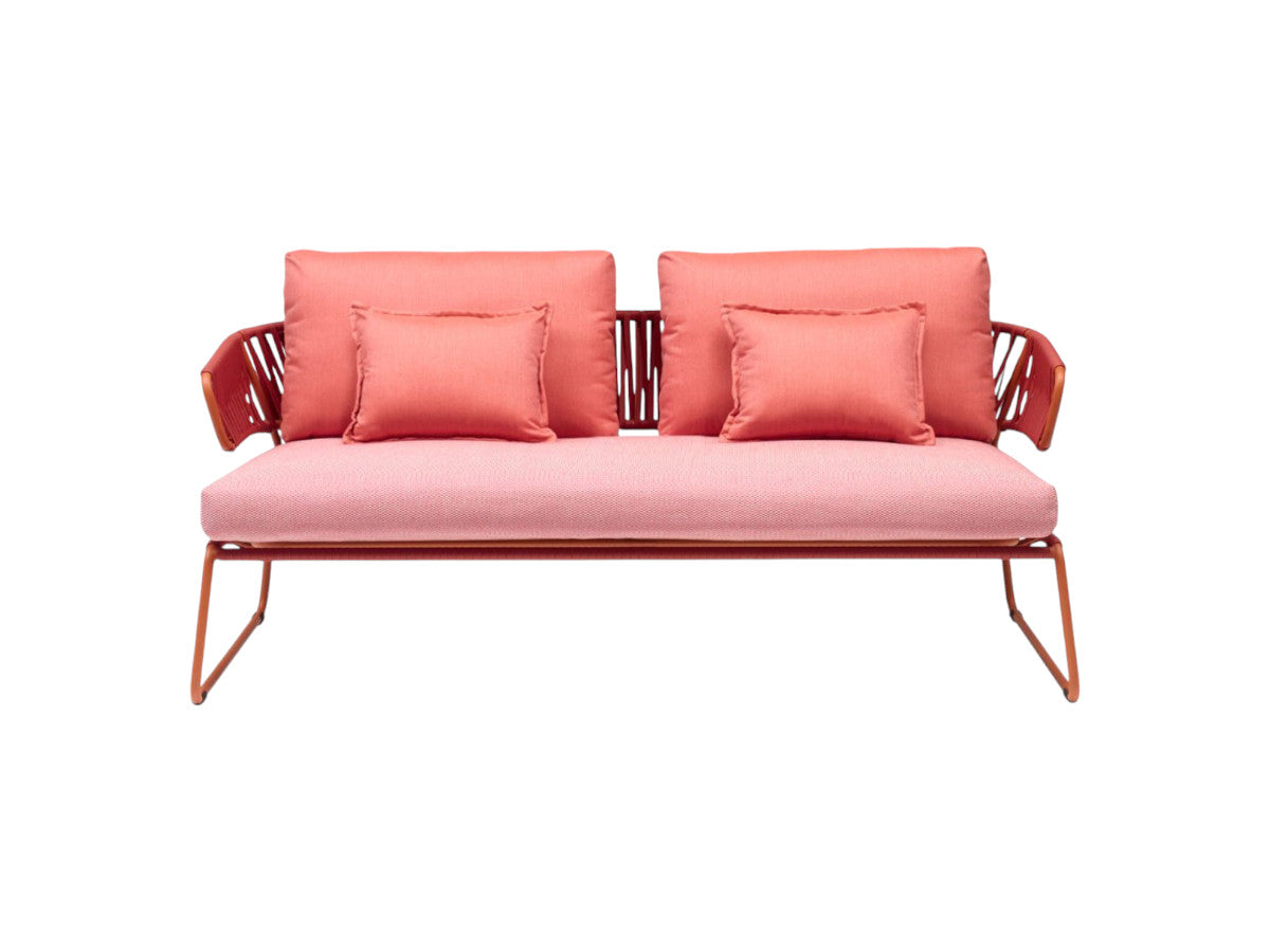 Front view of the Lisa Club outdoor sofa with coral upholstered cushions, woven armrests, and a matching metal frame.