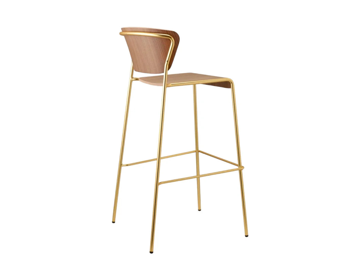 Rear angled view of the Lisa Wood bar stool with a walnut plywood seat and backrest, slim brass metal frame, and footrest.