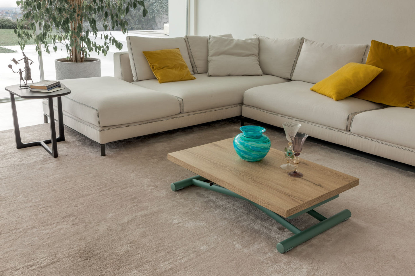 Low oak coffee table with green metal base styled in modern lounge setting