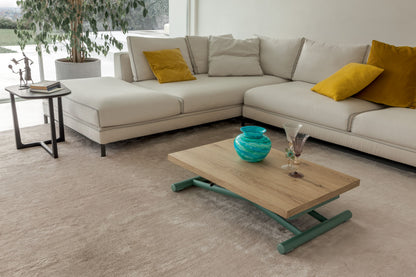 Low oak coffee table with green metal base styled in modern lounge setting