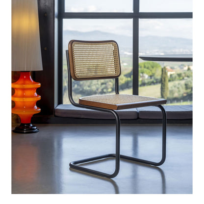 Marcel Breuer style Cesca cantilever chair with natural woven cane seat and backrest, solid wood frame and black tubular steel base, ideal for modern dining rooms, home offices and contemporary interiors.