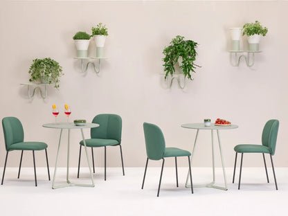 Mentha Pop 2720 upholstered dining chairs in sage green arranged around modern dining tables in a contemporary interior.
