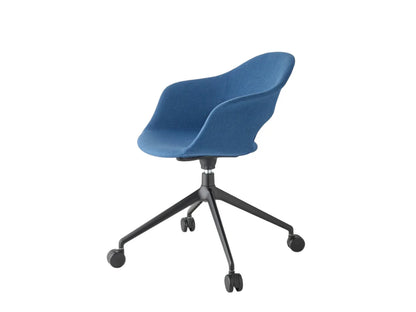Side angled view of the Mentha Pop office chair with blue upholstered shell seat, black swivel base, and castors.