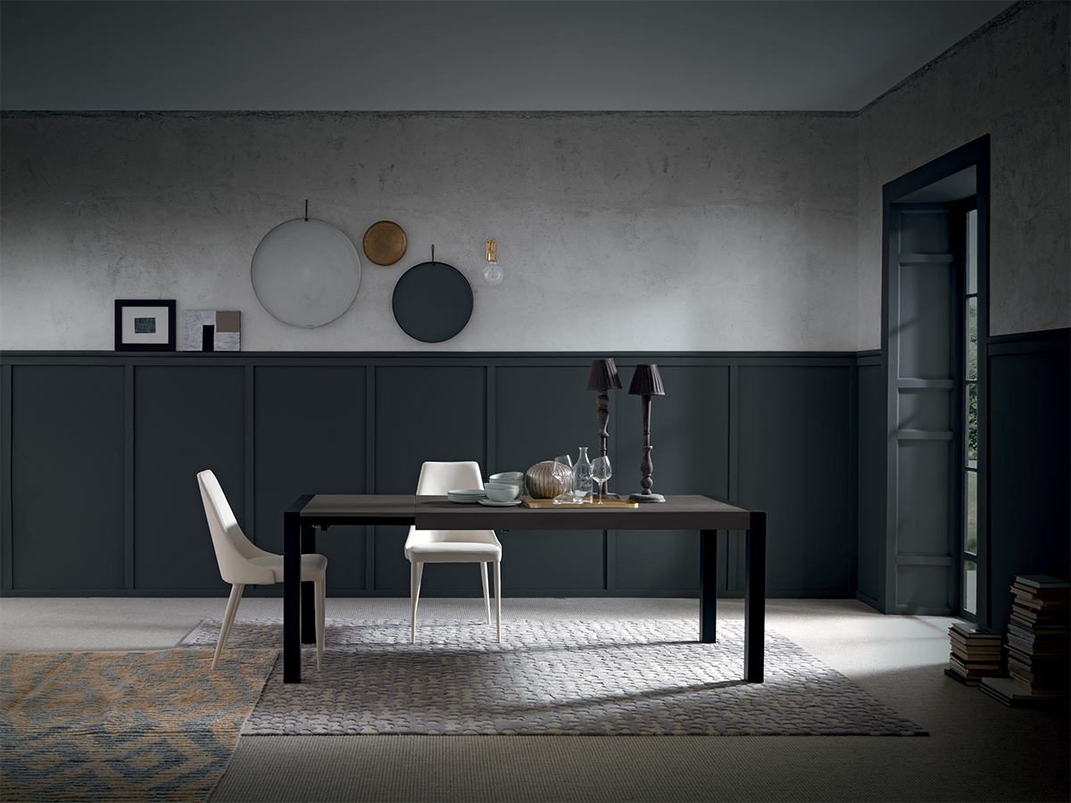 Side view of modern black dining table with minimalist decor and white chairs