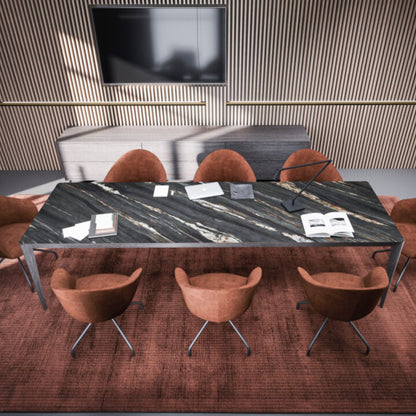 Modern rectangular black marble dining table with grey metal legs, styled in a contemporary dining room with upholstered terracotta chairs and decorative accessories