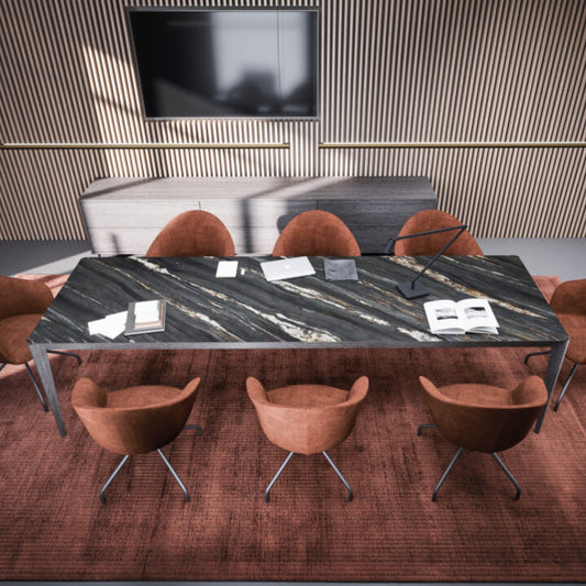 Modern rectangular black marble dining table with grey metal legs, styled in a contemporary dining room with upholstered terracotta chairs and decorative accessories