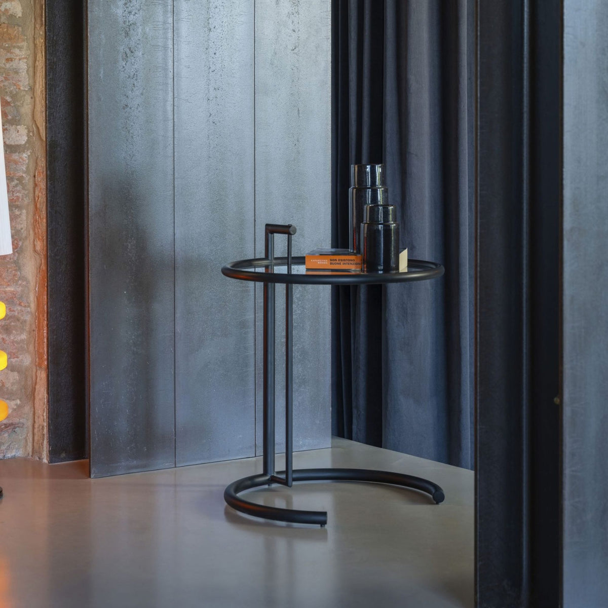 Modern round side table with a matte black metal frame and circular tray-style tabletop, featuring a minimalist tubular steel base, ideal as an accent table for living rooms, bedrooms, lounges and contemporary interiors.
