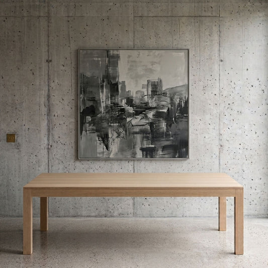 Modern rectangular light oak dining table with thick square legs in a minimalist dining room featuring exposed concrete walls, polished concrete flooring, and contemporary abstract artwork