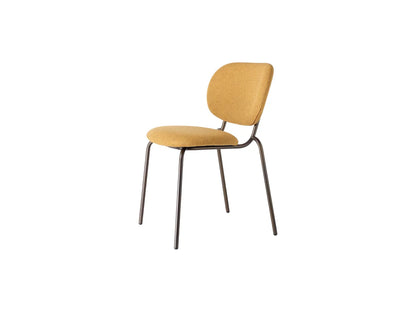 Front angled view of a mustard upholstered dining chair with a rounded backrest, padded seat, and slim dark metal frame.