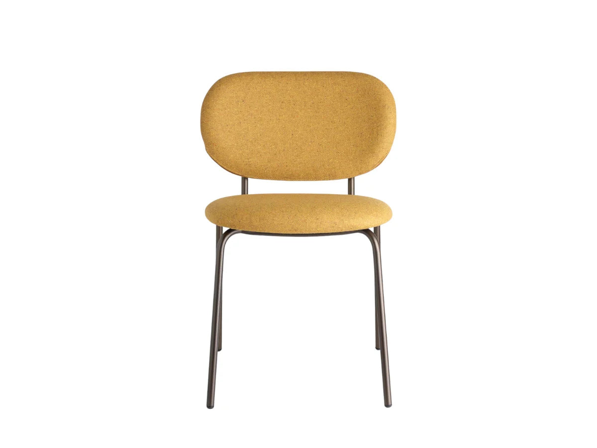 Front view of a mustard upholstered dining chair with a rounded backrest, padded seat, and slim dark metal frame.