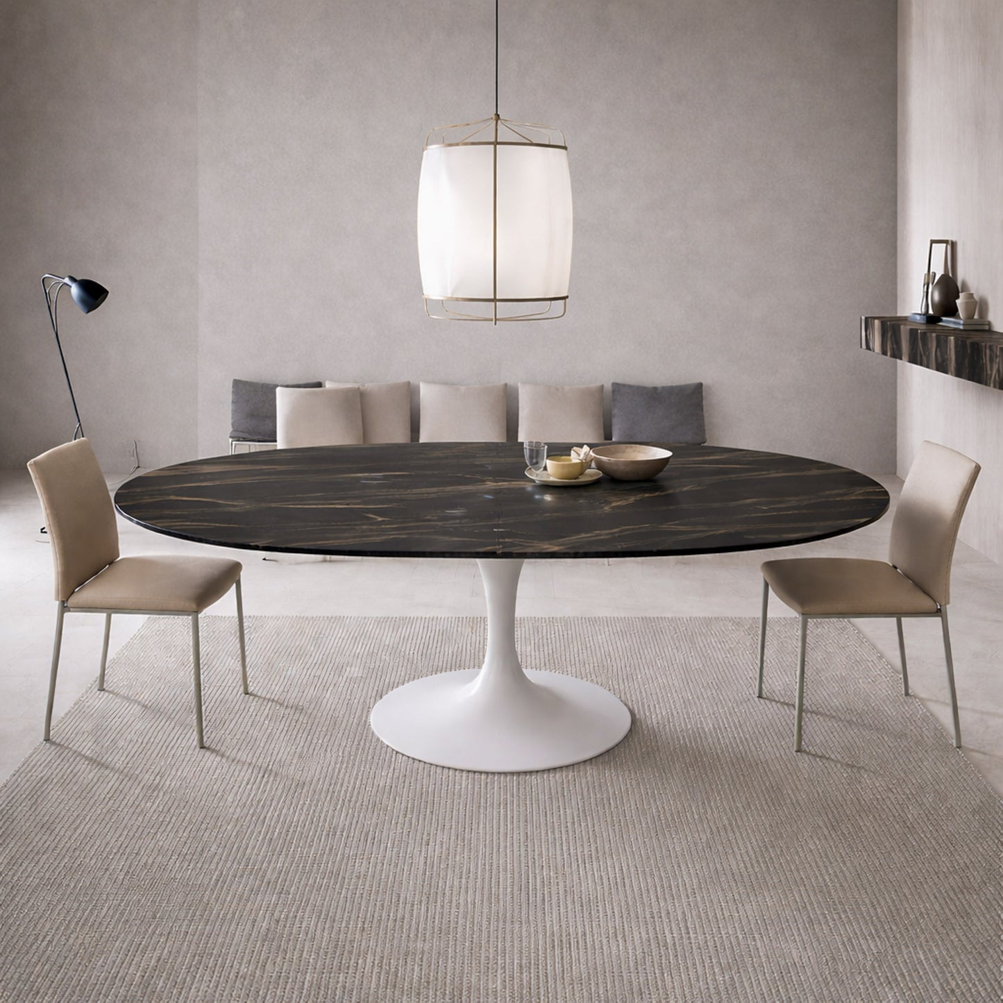 Extendable oval tulip dining table with Noir Desir ceramic black top and white pedestal base, shown open with extension leaves in a modern minimalist dining room.