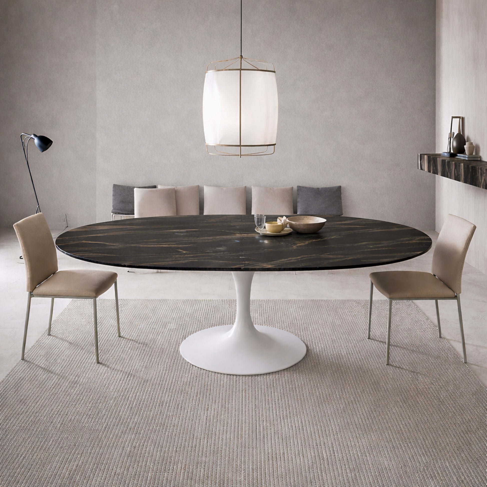 Extendable oval tulip dining table with Noir Desir ceramic black top and white pedestal base, shown open with extension leaves in a modern minimalist dining room.