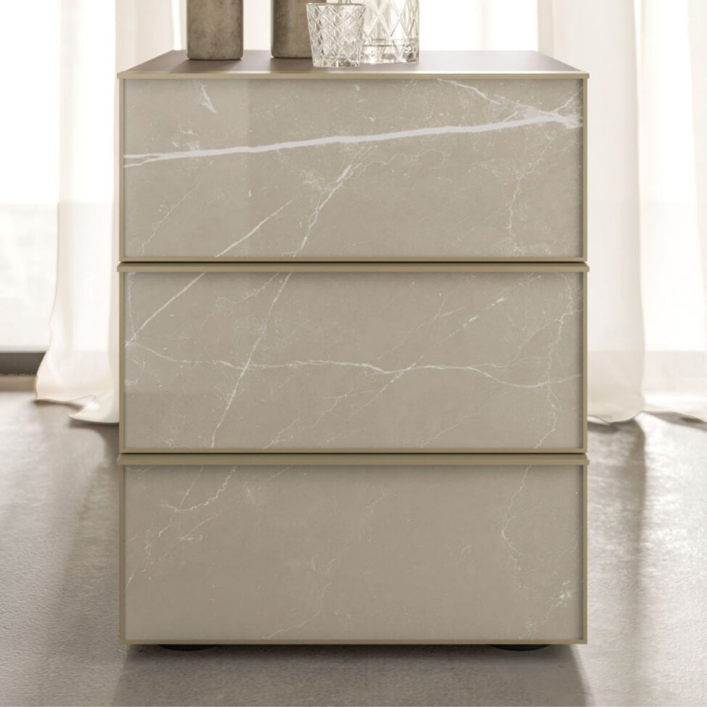 Marble-textured dresser with three drawers on a neutral background