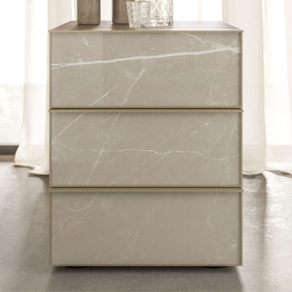 Marble-textured dresser with three drawers on a neutral background