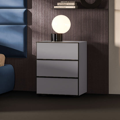 Gray nightstand with a lamp on top in a bedroom setting