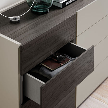 Open drawer of a modern furniture piece with items inside, featuring a neutral color scheme.