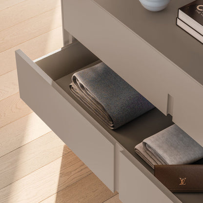 Folded gray towel in an open drawer with a wooden floor background