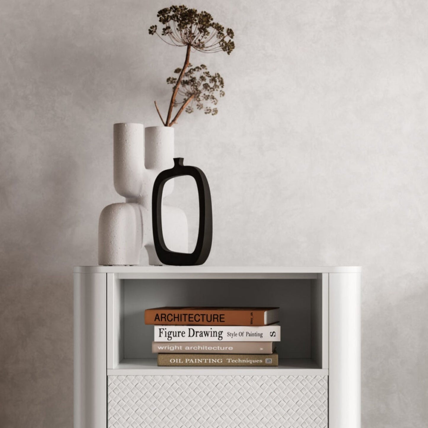 White cabinet with books and decorative vases on a neutral wall