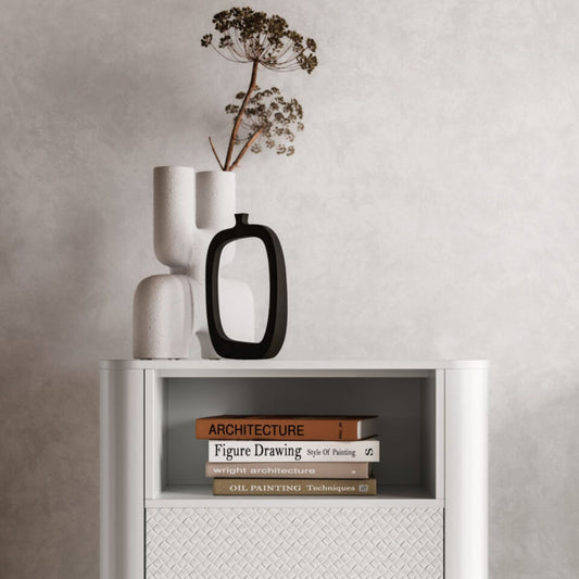 White cabinet with books and decorative vases on a neutral wall
