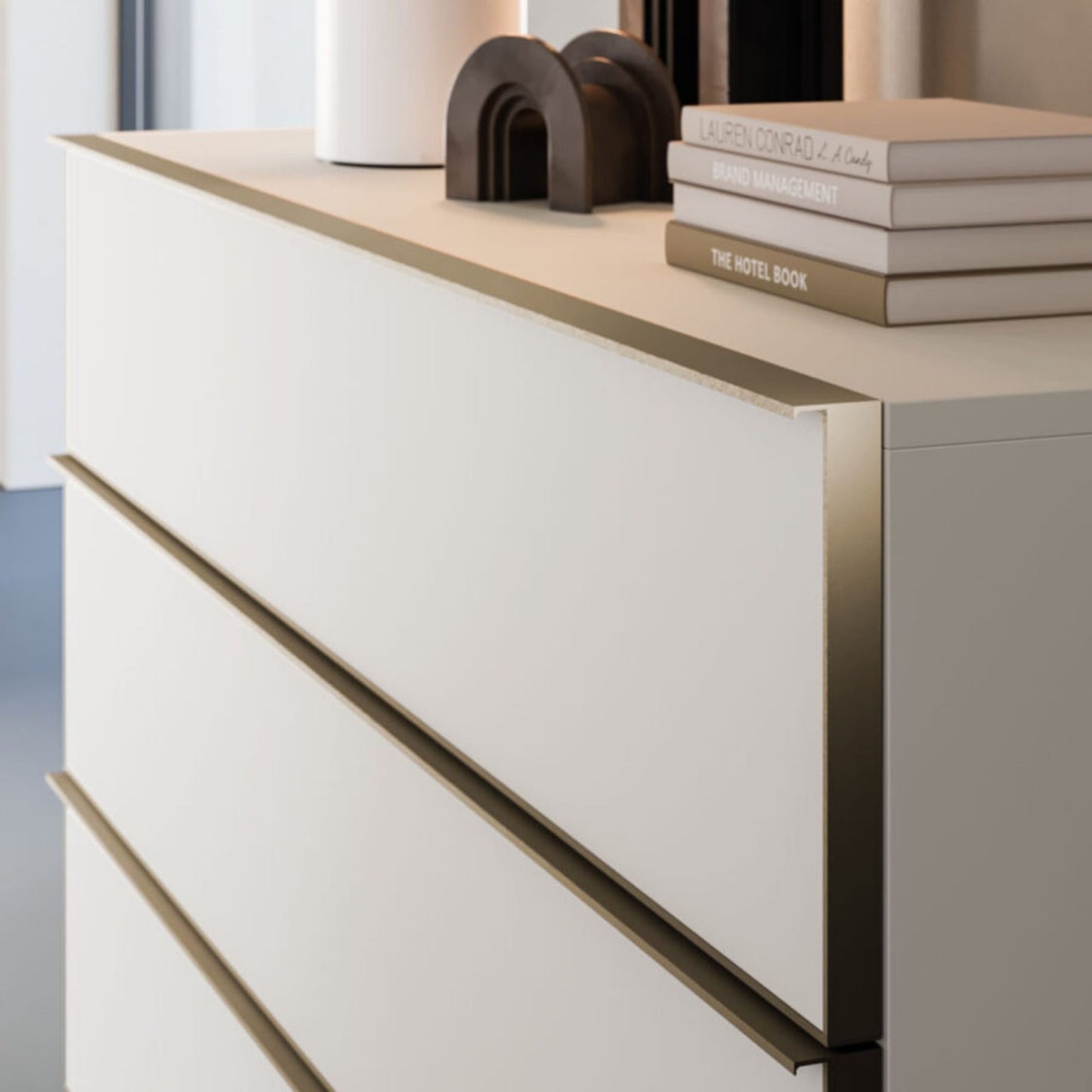 White dresser with gold accents and decorative items on top