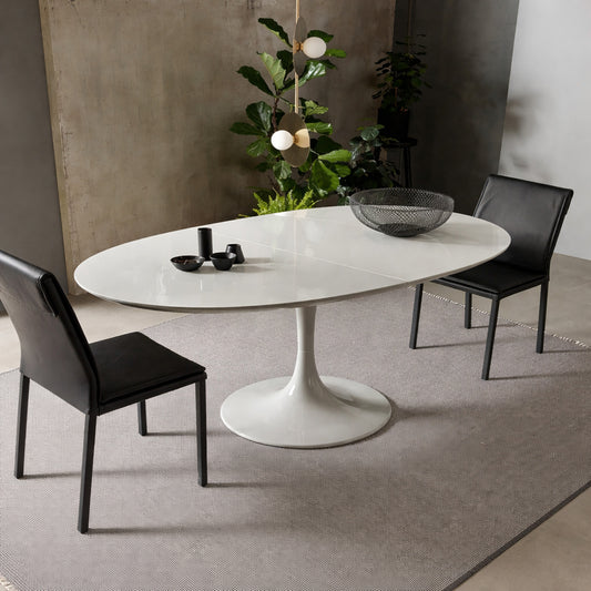 Extendable oval white tulip dining table with pedestal base shown open with central extension in a modern minimalist interior