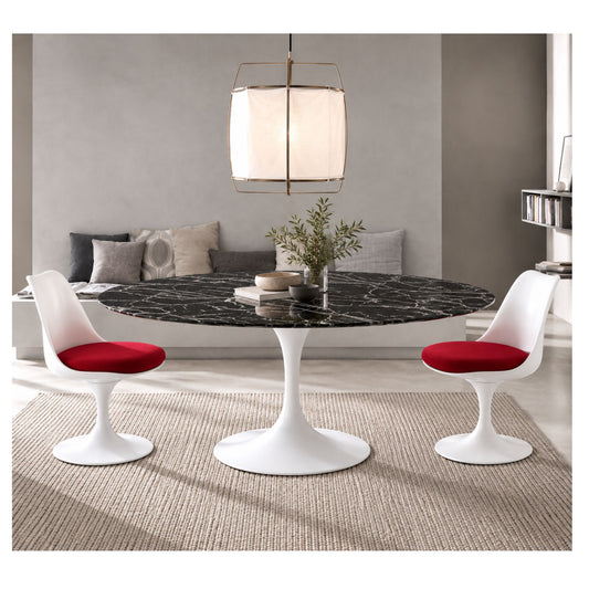 Oval Tulip dining table with a black veined ceramic top and white pedestal base, styled with red-seat chairs