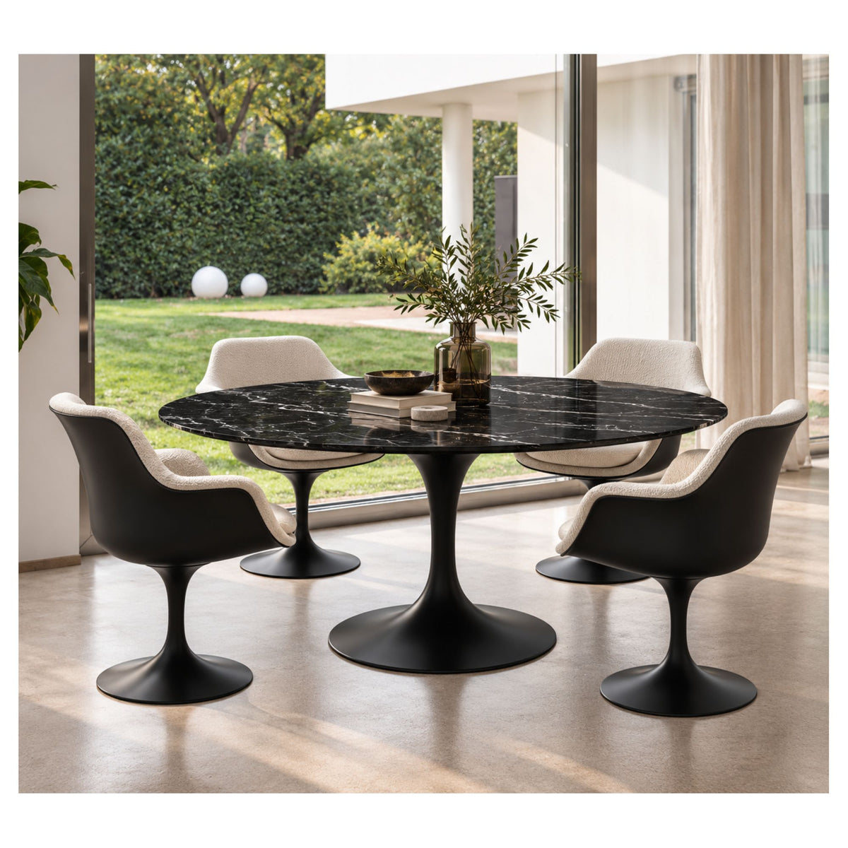 Oval Tulip dining table with a black veined ceramic top and black pedestal base, surrounded by four upholstered chairs.