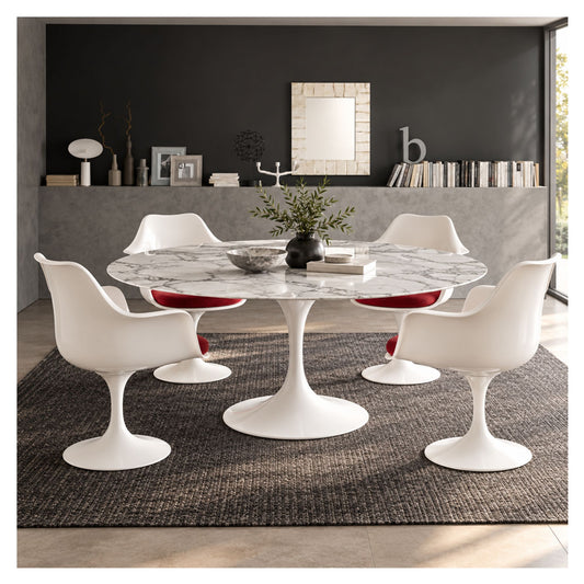 Oval white marble Tulip dining table with a white pedestal base, surrounded by four white chairs with red cushions in a modern dining room.