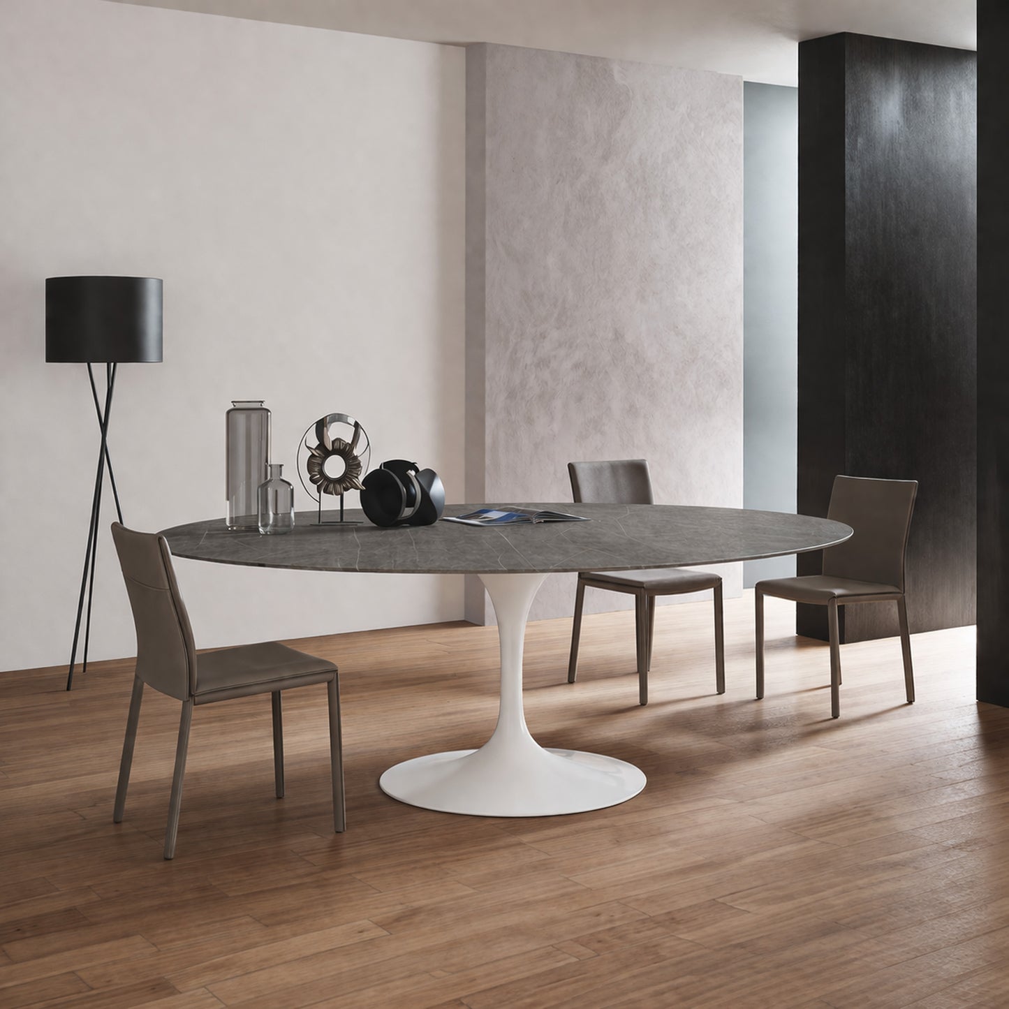 Oval tulip table Saarinen style with dark ceramic top and white pedestal base in modern dining room