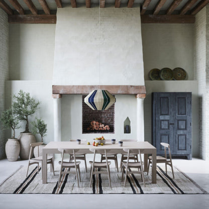 Round dark walnut pedestal dining table with a black tulip base styled in a modern luxury living room with neutral décor.