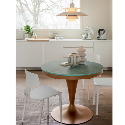 Round pedestal dining table with green ceramic top and copper pedestal base