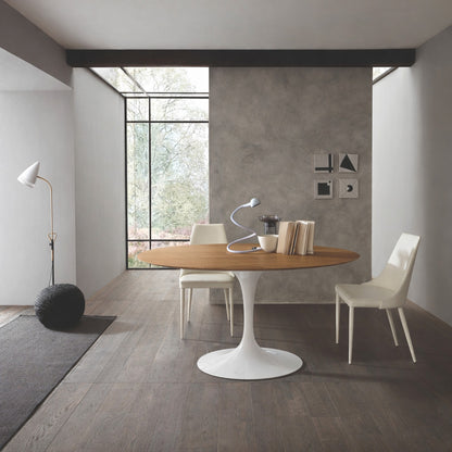 Round tulip table Saarinen style with black marble top and white pedestal base in minimal modern dining room