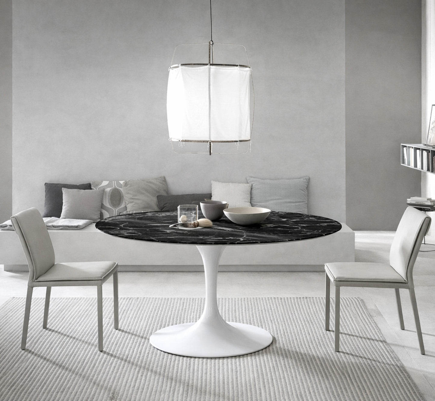 Round tulip table Saarinen style with black marble top and white pedestal base in modern dining room