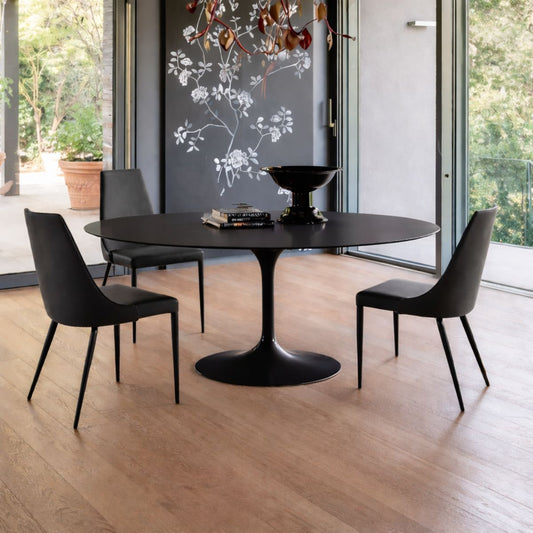Round tulip table Saarinen style with black top in modern dining room with large windows