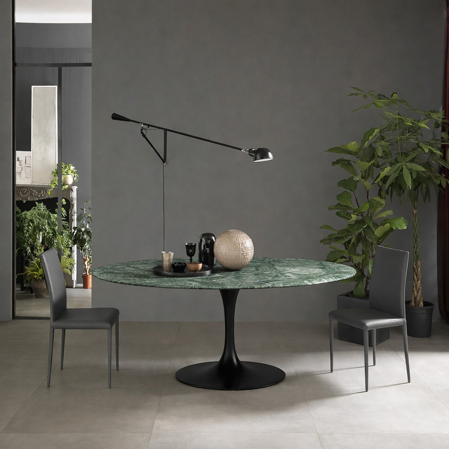 Round tulip table Saarinen style with green marble top and black pedestal base in modern dining room