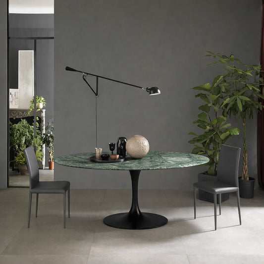 Round tulip table Saarinen style with green marble top and black pedestal base in modern dining room