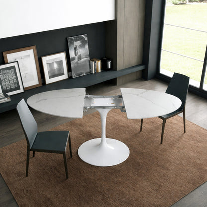 Round tulip table Saarinen style with white marble top extendable open in modern dining room