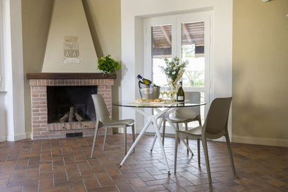 SCAB Hug recycled technopolymer dining chairs around a glass dining table in a contemporary Italian dining room, suitable for indoor and outdoor use, Made in Italy