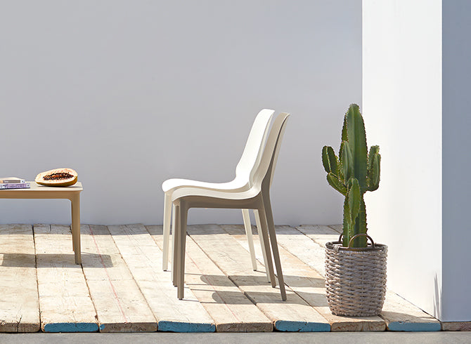 SCAB Hug stackable dining chairs in recycled technopolymer displayed on a contemporary outdoor terrace, ideal for patios, gardens and commercial outdoor spaces, Made in Italy